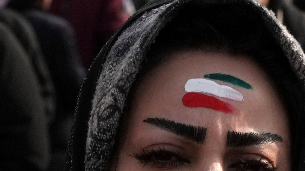 Iranische Frau mit den Landesfarben auf der Stirn