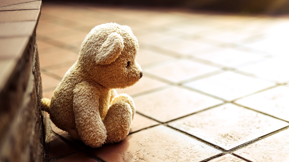 Kleiner Teddybär bei gefliesten Stufen