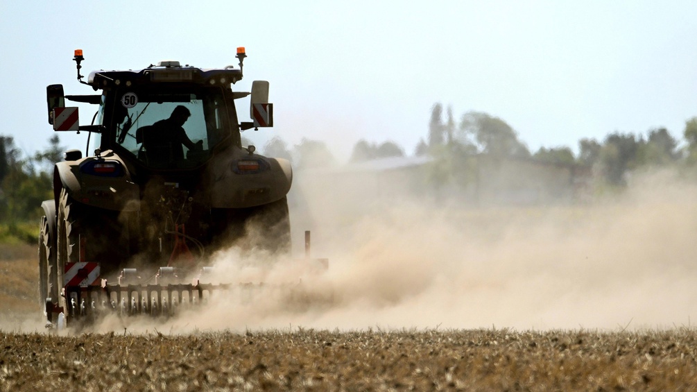 Traktor auf dem Feld: Staub und trockene Erde