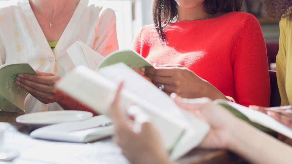 Frauen am Tisch mit Büchern in Händen