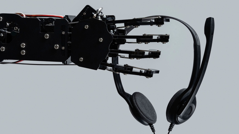Eine Roboterhand hält ein Headset.