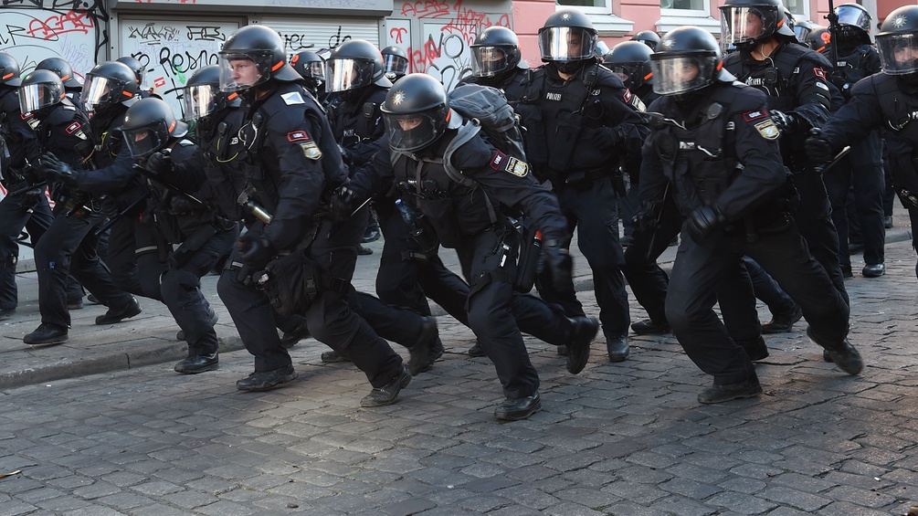 Ein Trupp Polizisten läuft gegen Demonstranten an