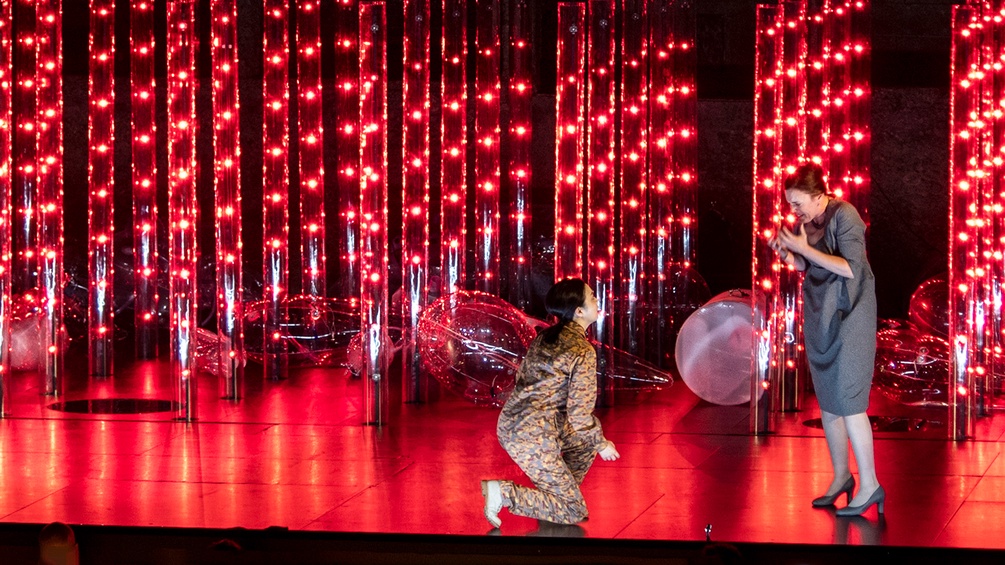 Ying Fang (Ilia), Nicole Chevalier (Elettra) auf einer rot erleuchteten Bühne
