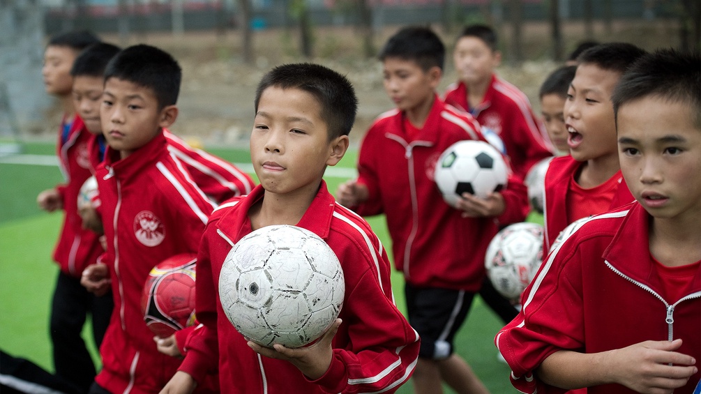 Chinesische Jungen trainieren Fußball