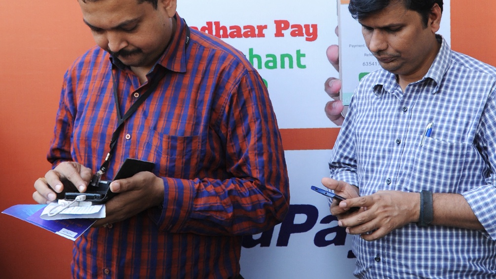 Zwei Männer in Indien bei einer Messe für digitale Währungen.