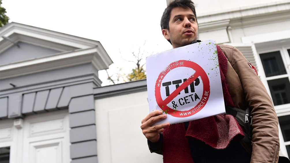 Ein Demonstrant hält ein Schild hoch: "Stop TTIP & CETA"