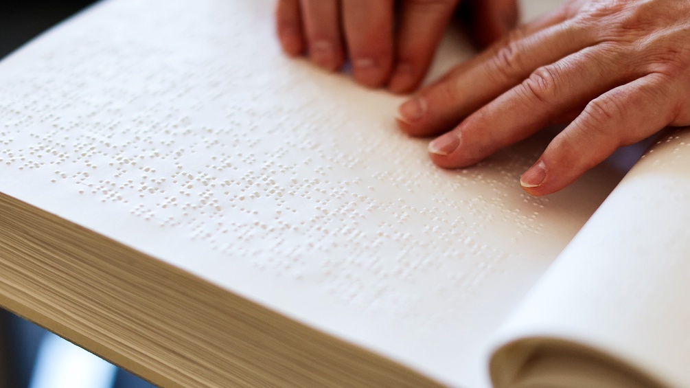 "Herr der Ringe" in Braille-Schrift: lesende Finger