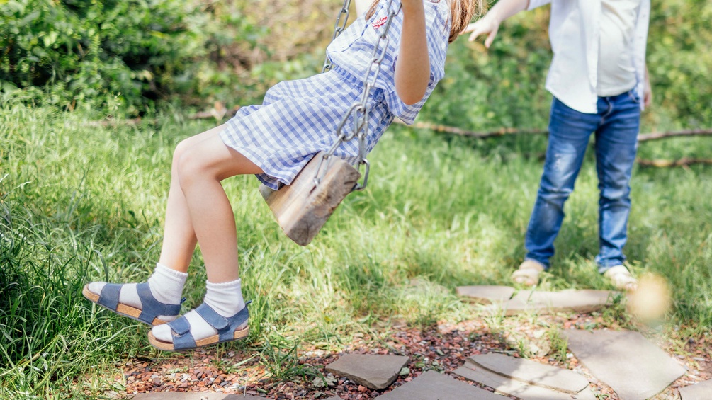 Schaukelndes Mädchen, Kinder auf dem Spielplatz