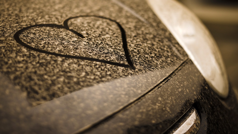 Saharastaub auf einer Motorhaube eines Autos - gezogenes Herz im Staub