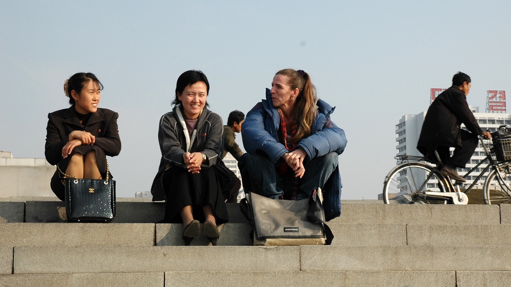 Brigitte Weich mit koreanischen Frauen auf einer Stufe sitzend, bei der Arbeit