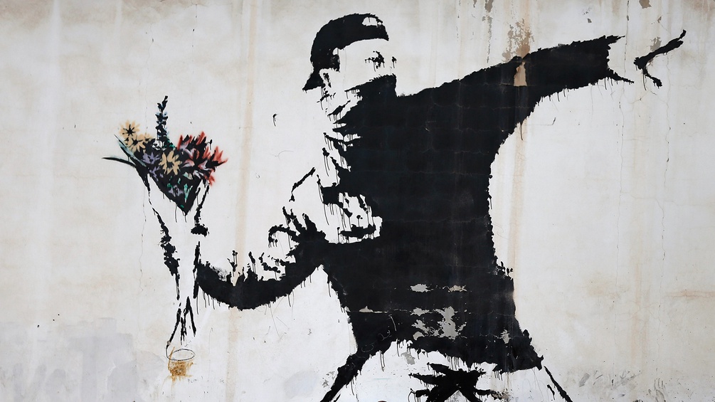 Vermummter Mann mit Blumenstrauß - Graffiti vom Künstler Banksy