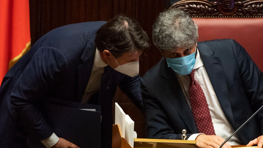  Giuseppe Conte und Roberto Fico besprechen sich währrend sie Masken tragen.