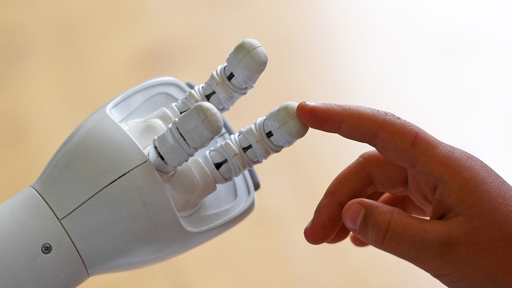 Roboterhand und Kinderhand