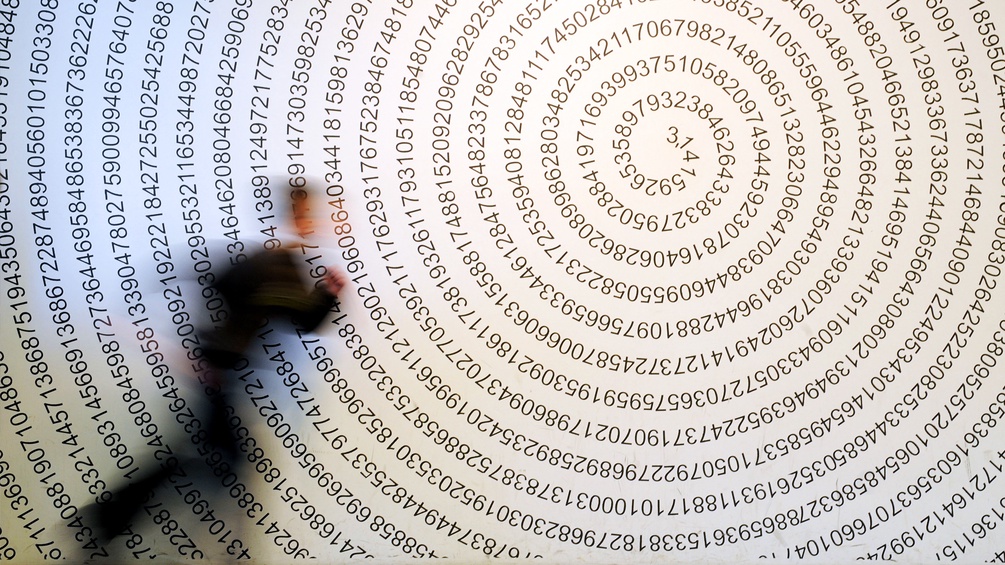 Ein Mensch rennt an einer Wand vorbei mit der Zahl Pi aufgedruckt