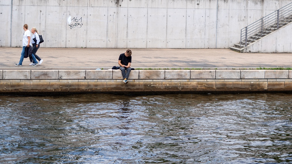 Lesender Mensch an der Spree in Berlin
