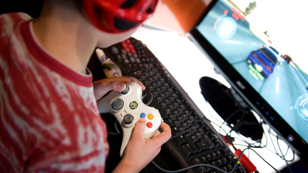 Kind spielt Xbox Videospiele am PC.