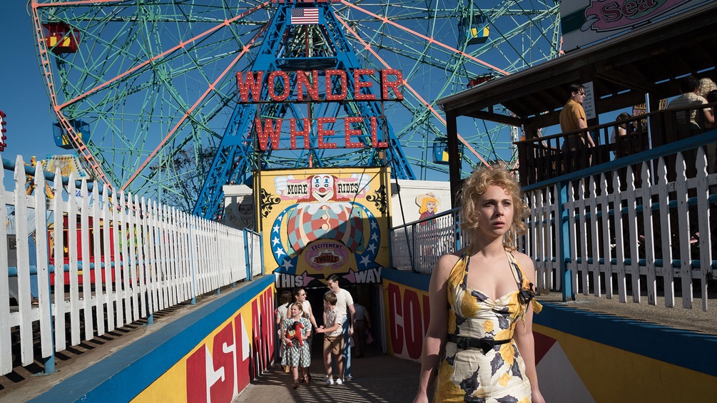 Blonde Frau in einem Sommerkleid vor dem Riesenrad