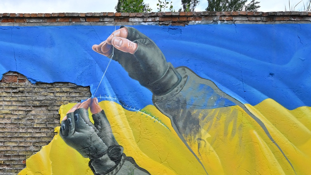 Graffiti zeigt die ukrainische Fahne, die zusammengeflickt wird