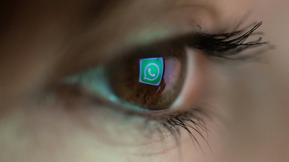 Das Whatsapp Logo spiegelt sich im Auge der Betrachterin