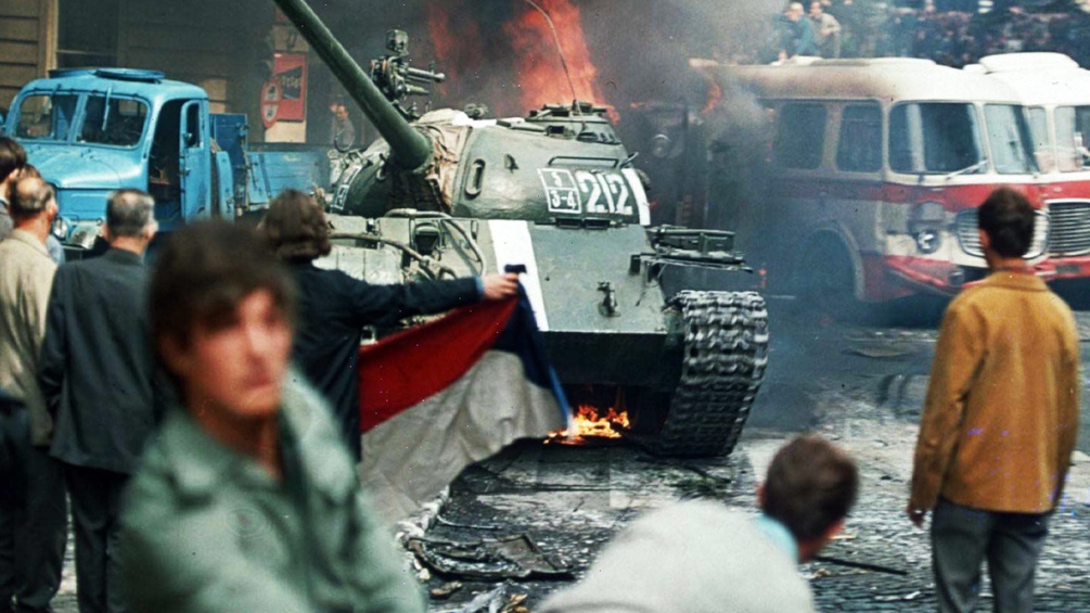 Prager Brüger mit der tschechoslowakischen Flagge werfen brennende Fackeln auf einen sowjetischen Panzer. 