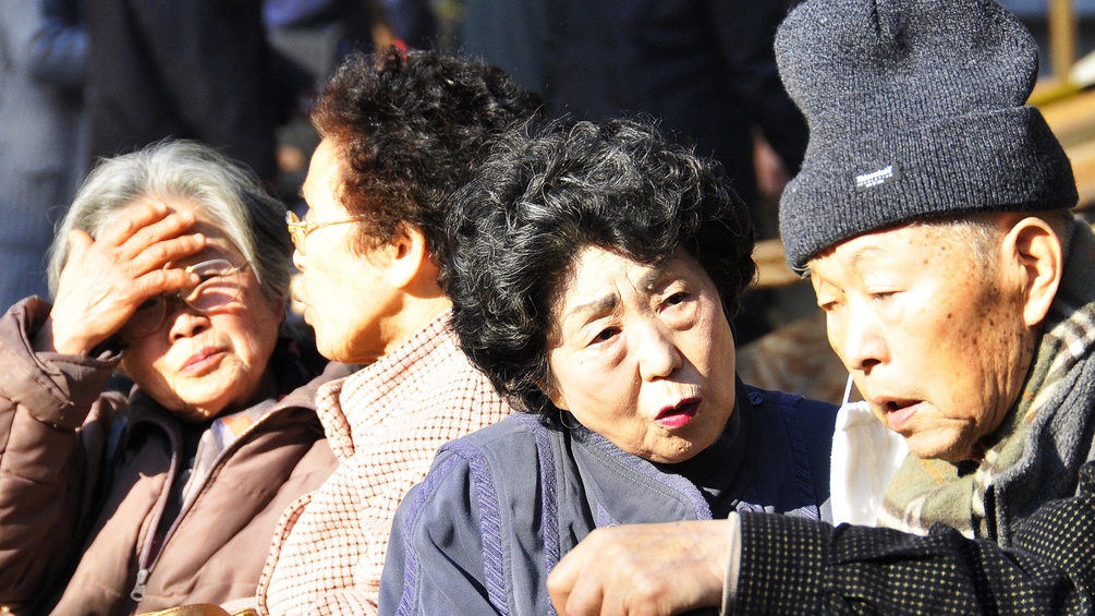 Alte Japaner und Japanerinnen sitzen in der Sonne