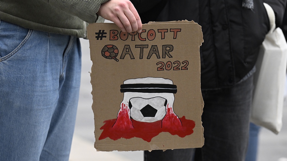 Ein Demonstrant hält einen Karton auf dem Boykott Qatar steht.