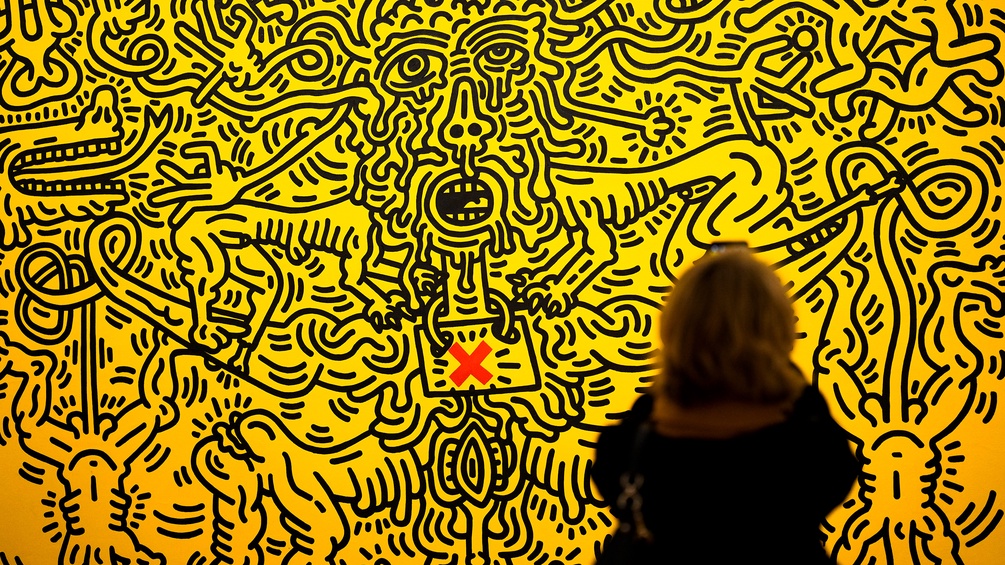 "Aids" von Keith Haring, von einer Frau betrachtet