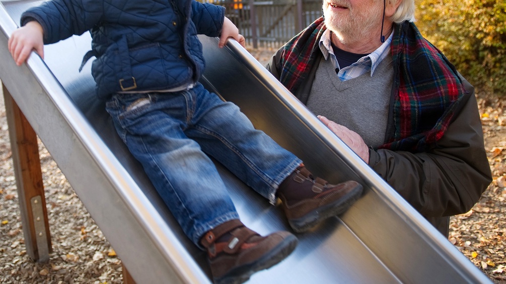 Großvater mit Enkel bei einer Rutsche