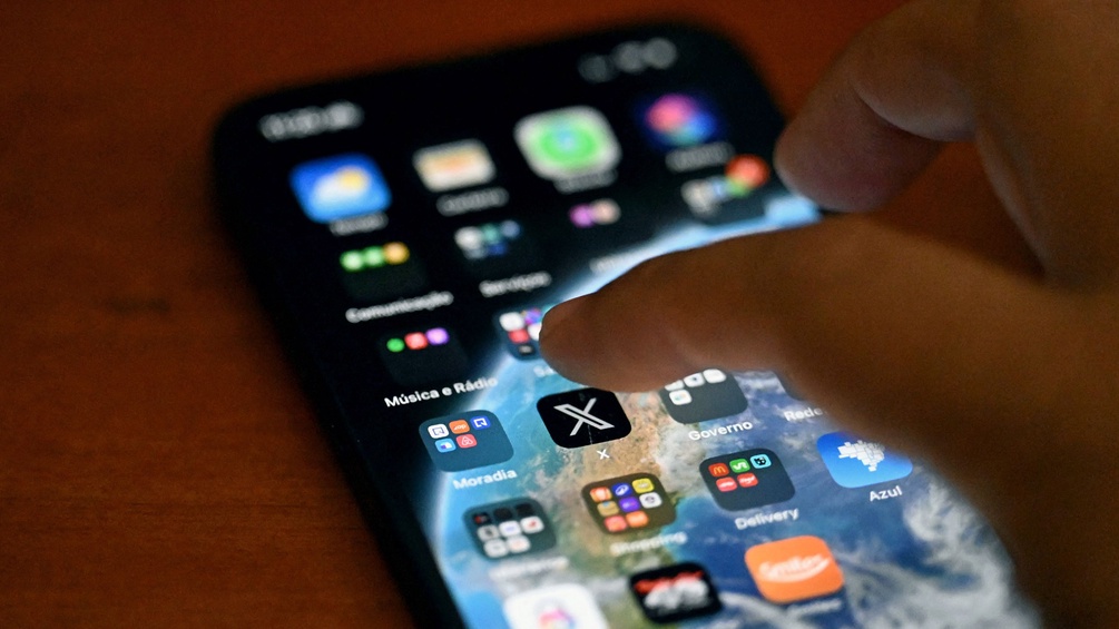 Männerhand über einem Smartphone-Display: Social-Media-Plattform X