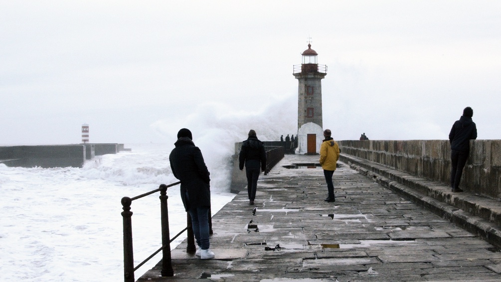 Vier Männer an der Küste bei einem Leuchtturm