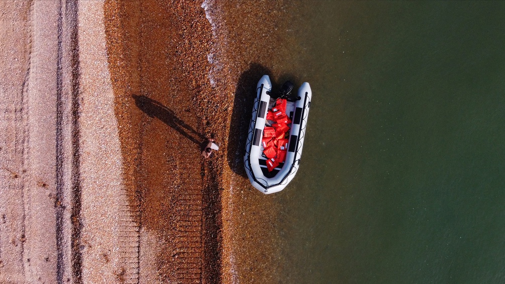 Ein Boot mit Schwimmwesten aus der Vogelperspektive.