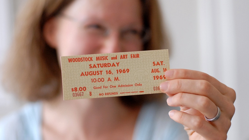 Sabine Nikolay hält eine Woodstock-Eintrittskarte in der Hand