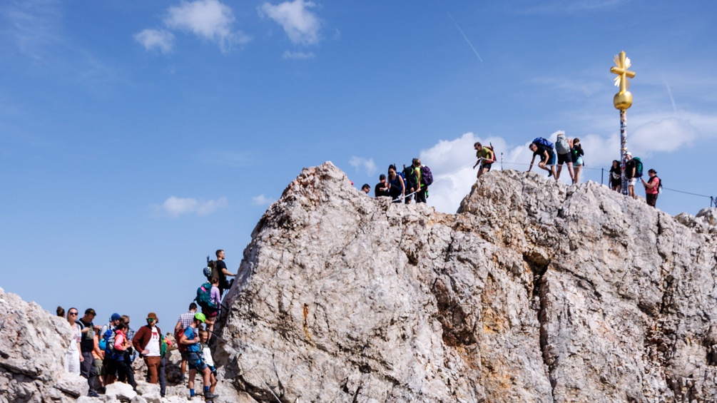 Alpine Kletter:innen auf der deutschen Zugspitze, Gipfelkreuz