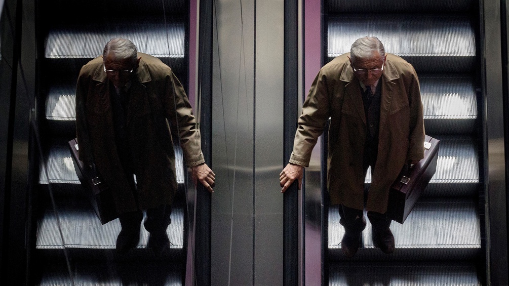 Jiri Menzel auf einer Rolltreppe mit dem Spiegelbild