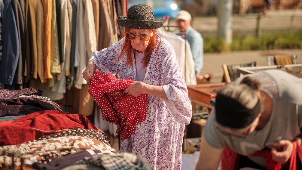 Eine Frau mit Altkleidern am Flohmarkt