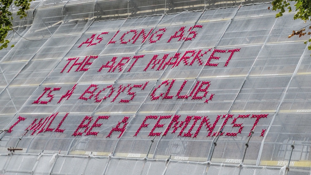 Auf der Universität der bildenden Künste wurde ein feministischer Text mit Kreuzstich auf Bauplanen geschrieben.