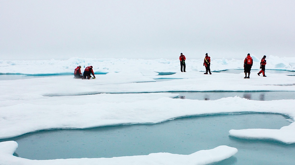 Menschen auf Eisschollen in der Arktik