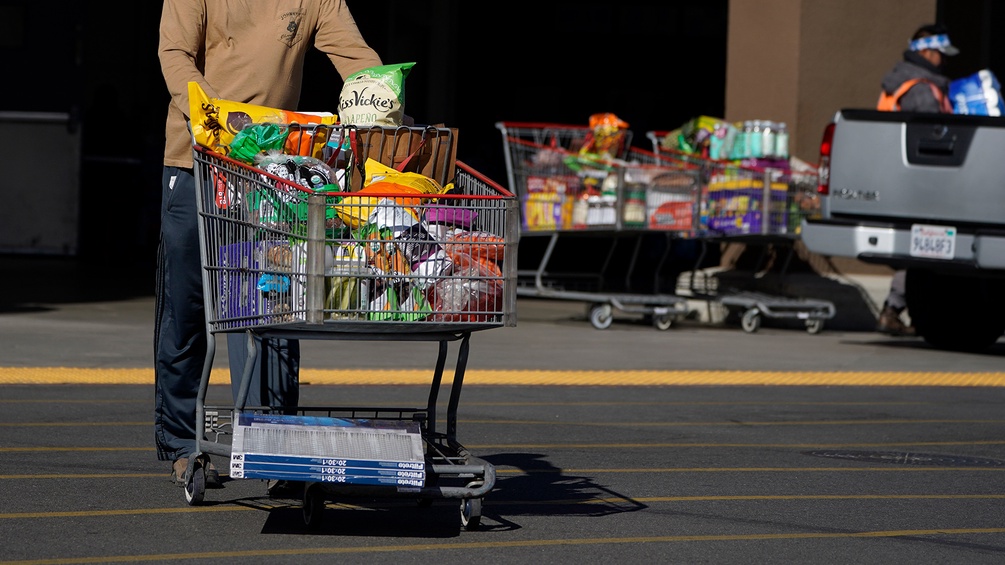 Ein Mann schiebt einen Einkaufswagen vor einem Supermarkt in den USA (Costco)