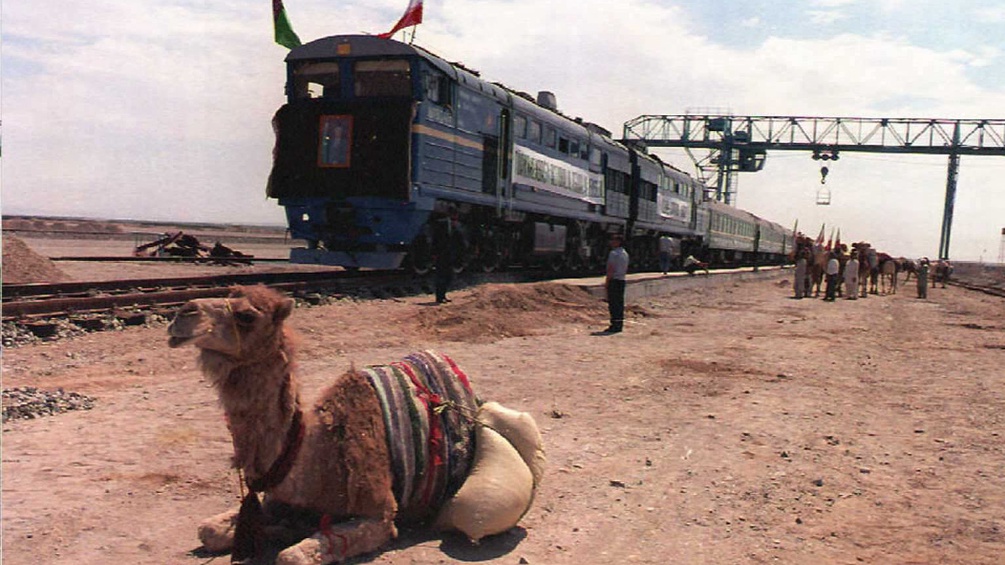 Ein Kamel vor einem Zug der Silkroad.