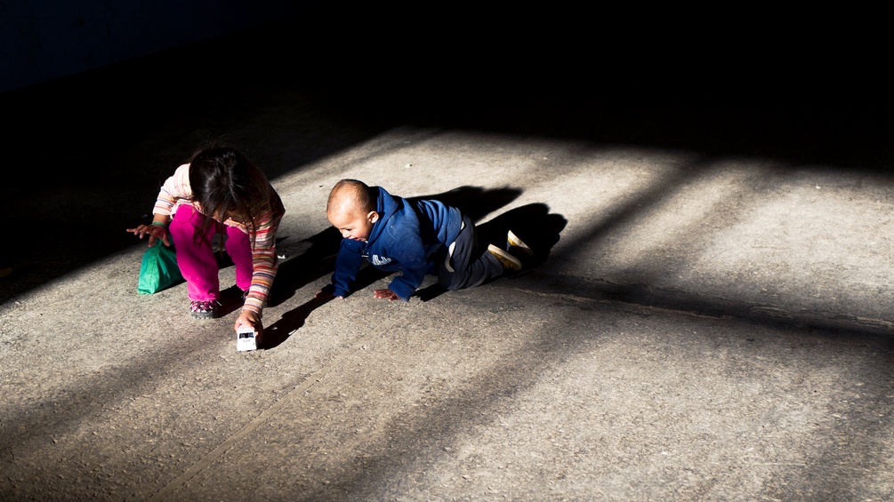 Zwei Kinder spielen am Steinboden