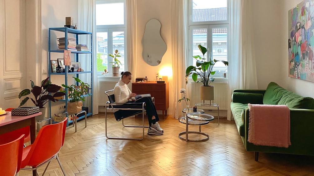 Eine Frau liest sitzend in ihrer Wohnung - "wie wien wohnt"