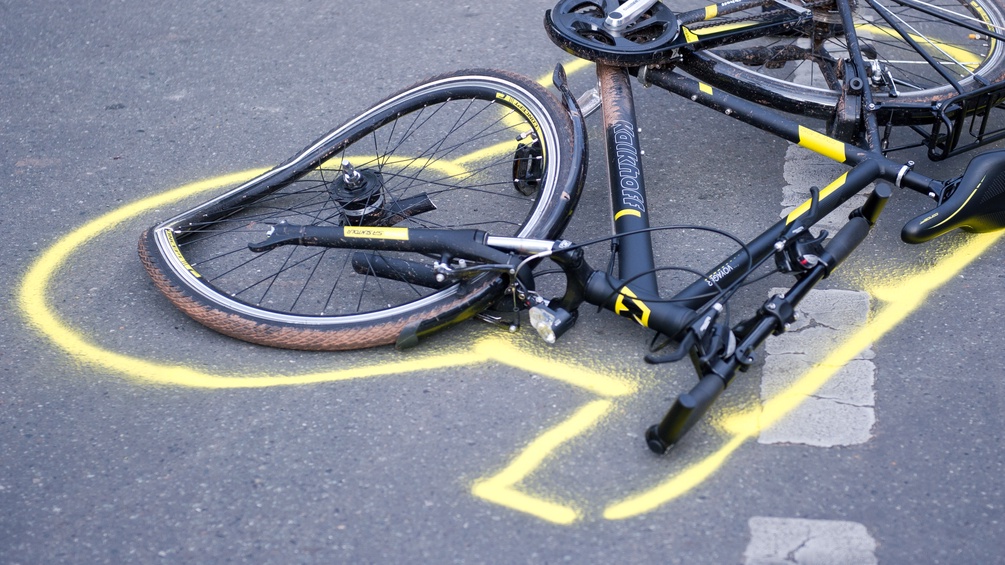 Bild eines zerknautschten Fahrrads am Boden nach einem Unfall.
