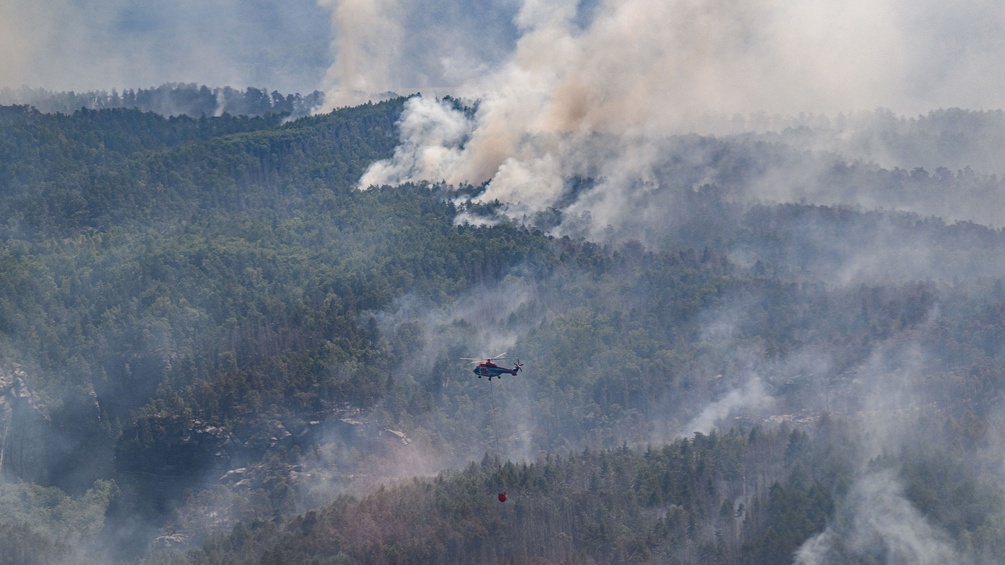 Waldbrand wird von Helikoptern gelöscht.
