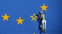 Ein Bild auf einer Hauswand, auf dem ein Mann die Sterne aus dem EU-Banner meißelt