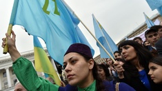 Frau bei einer Demonstration mit Krimtataren-Fahne