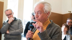 Ein älterer Herr spricht ins Mikrofon