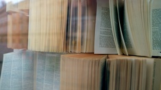 Aufgeklappte Bücher hinter Glas