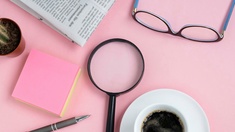 Post-it, Lupe, Zeitung und eine Tasse Caffe