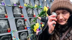 Weinende Frau in der Ukraine vor Erinnerungstafeln verstorbener Maidan-Aktivisten