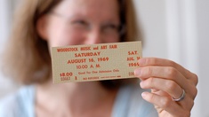 Sabine Nikolay hält eine Woodstock-Eintrittskarte in der Hand